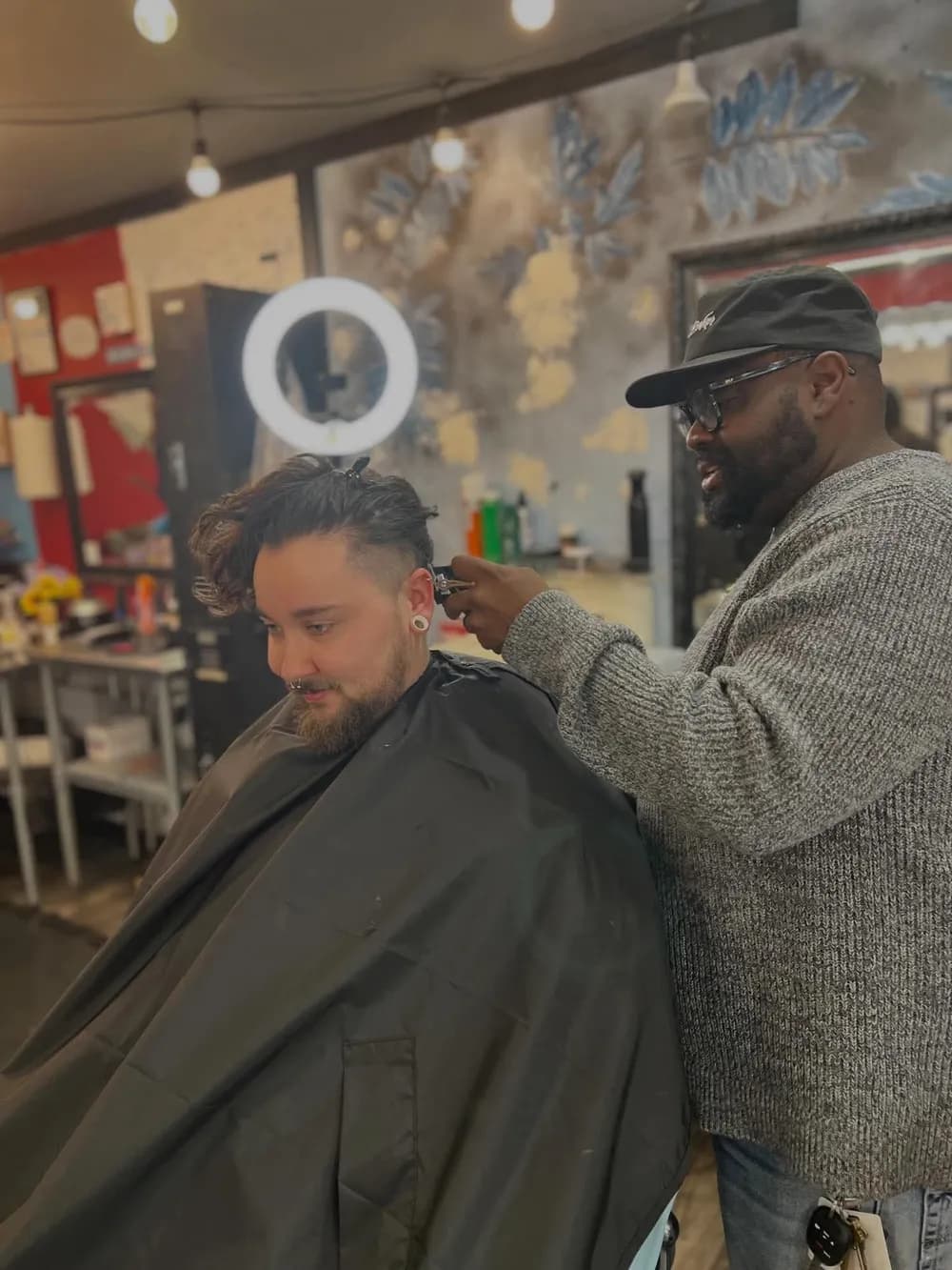 A barber lining up a client's cut with clippers at Barber Shack.