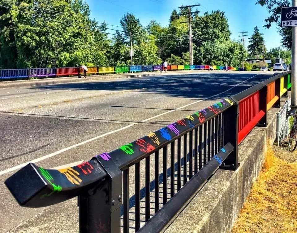 The Rainbow Bridge on Northwest Avenue in Bellingham, its railings painted in rainbow colors and decorated with children's handprints.