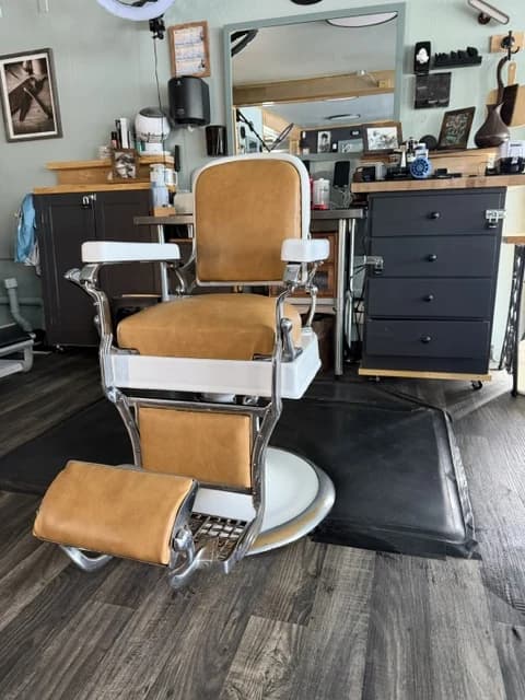 A vintage barber chair standing ready on the shop floor.